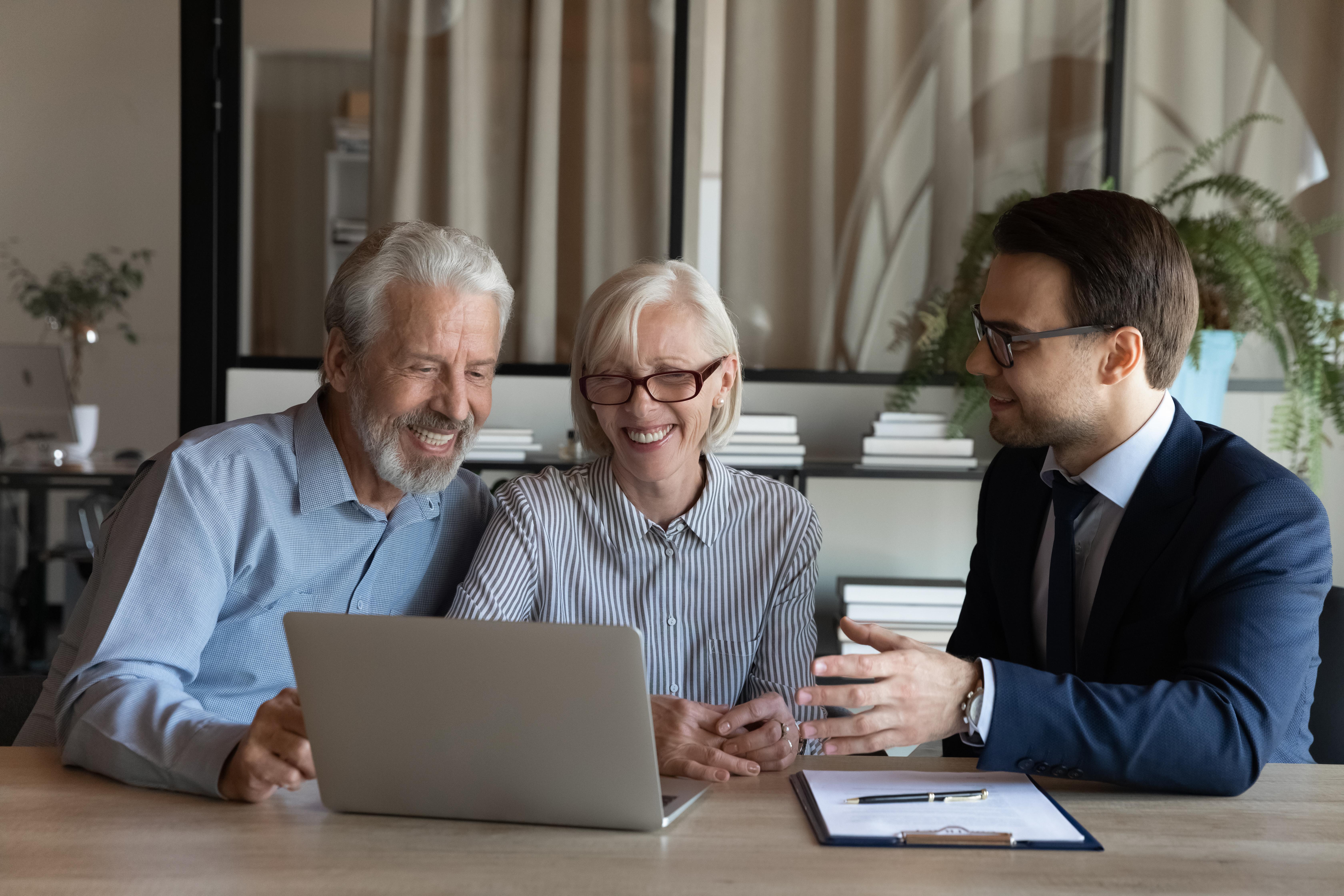 Älteres Pärchen mit jungem IT-Support am Laptop